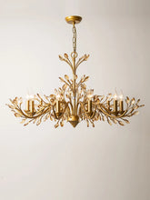 Brushed gold chandelier with crystal accents and floral-inspired arms, shown against a white background.