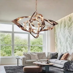 A modern rose gold geometric crystal pendant light hanging in a bright living room with large windows.