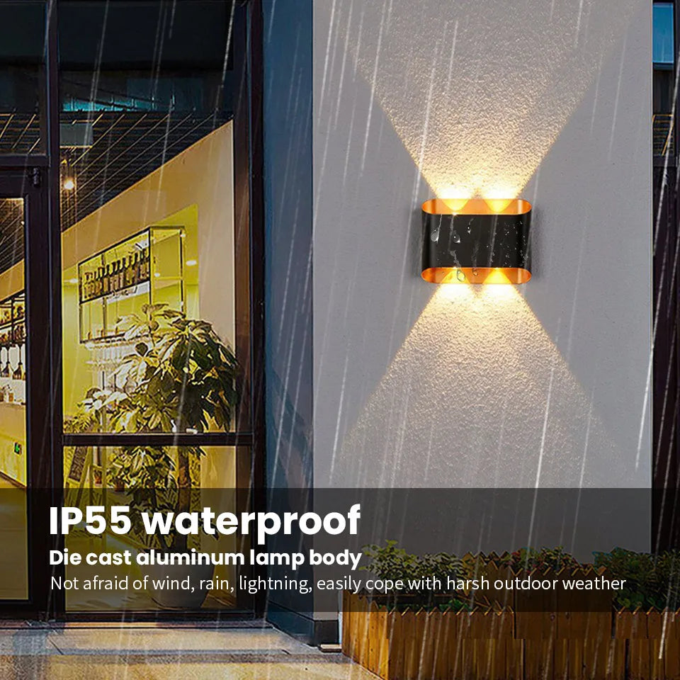 Outdoor wall light fixture on a building exterior with raindrops on the glass.