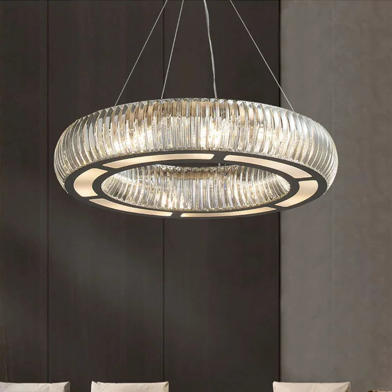 Close-up of a circular chrome pendant light showcasing its crystal details and inner LED lighting.
