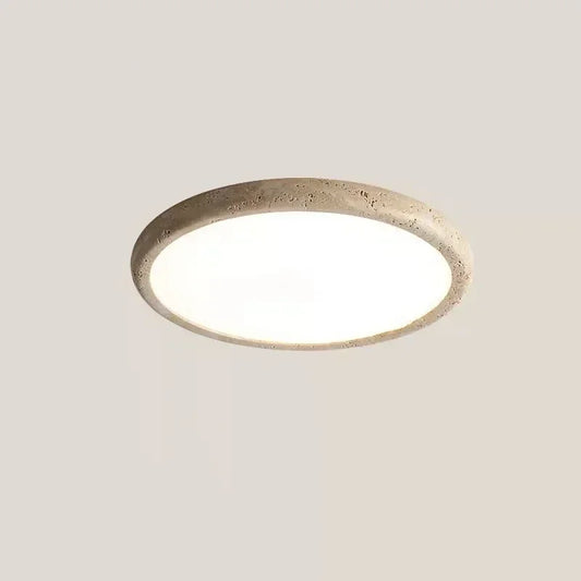 A circular flush mount ceiling light with a textured, stone-like beige frame and a smooth white diffuser.