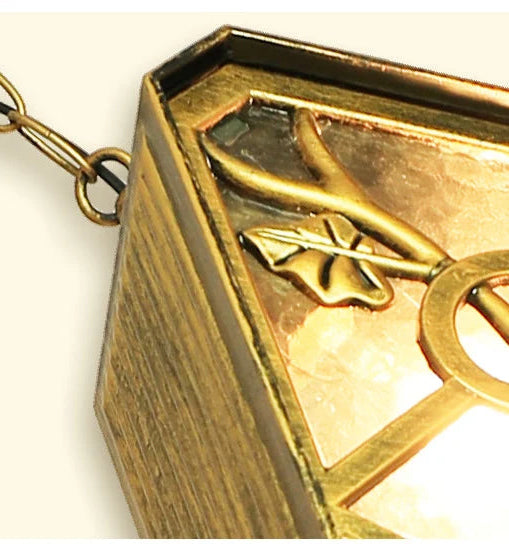 Gold pendant with a design on a white background