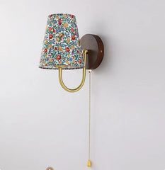 Wall-mounted lamp with floral-patterned shade on a white background