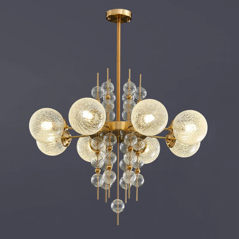 Gold chandelier with glass globe lights on a dark background