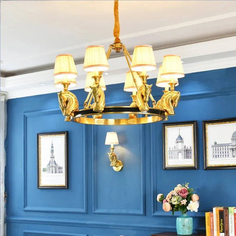 Gold chandelier hanging in a room with blue walls and framed pictures.