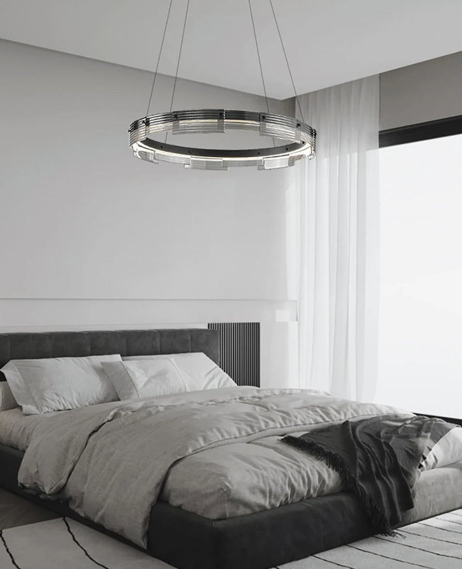 Modern bedroom with a chandelier hanging above a bed.