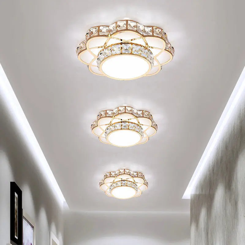 Close-up of a gold and crystal flower flush mount ceiling light with a central LED.