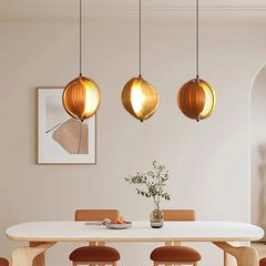 Modern dining room with pendant lights, table, and chairs.
