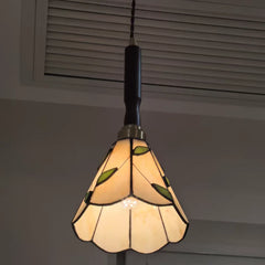 Stained glass pendant light with leaf design on a neutral background
