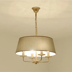Gold chandelier with beige lampshade on a beige background