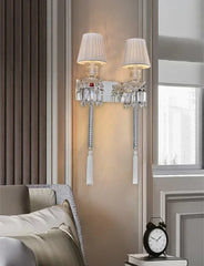 Decorative wall sconces with tassels on a wall next to a window.