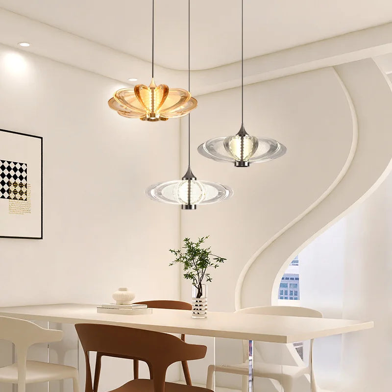 Modern dining room with pendant lights and a table.
