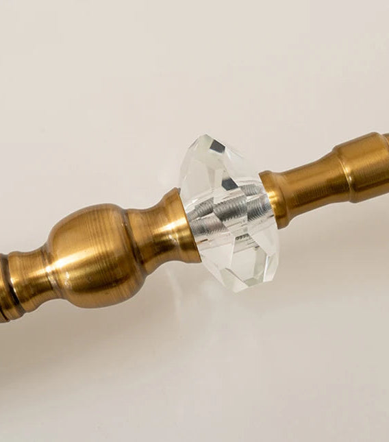 Decorative object with brass and crystal design on a beige background