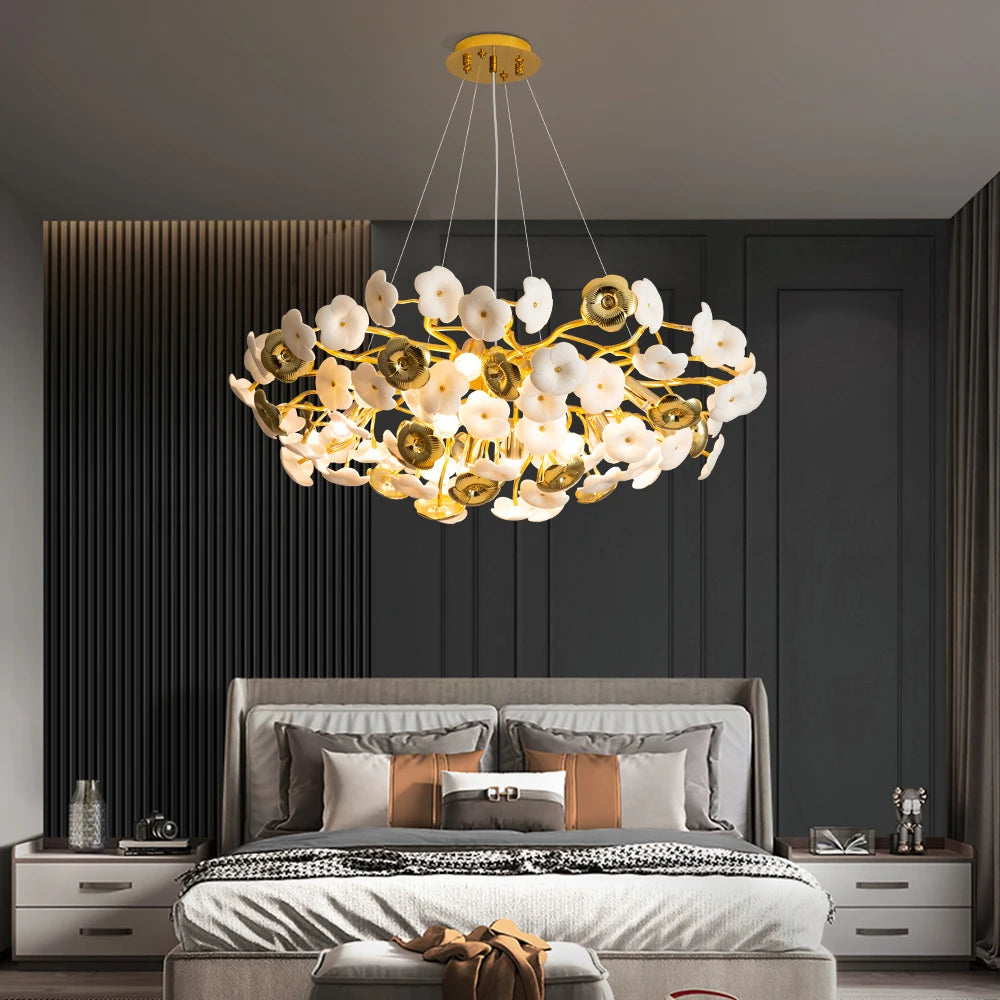Luxury chandelier hanging above a bed in a modern bedroom setting.