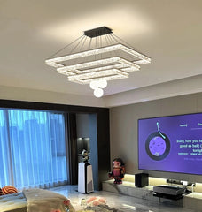 Modern living room with a chandelier, TV, and decorative items.
