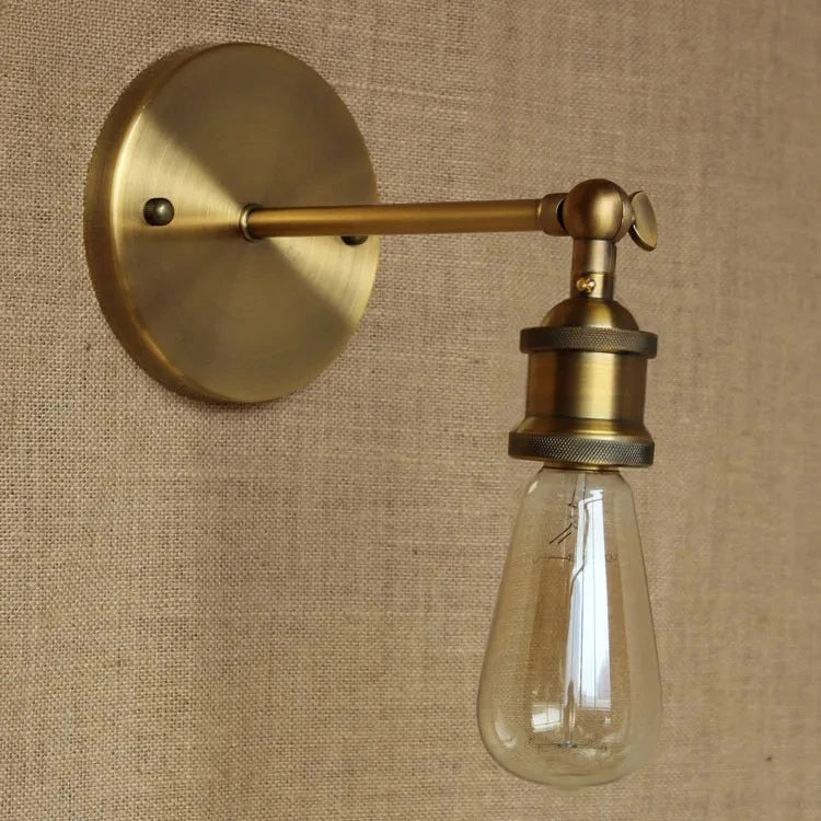 A gold cone shade wall sconce mounted on a textured wall, showcasing its industrial design.