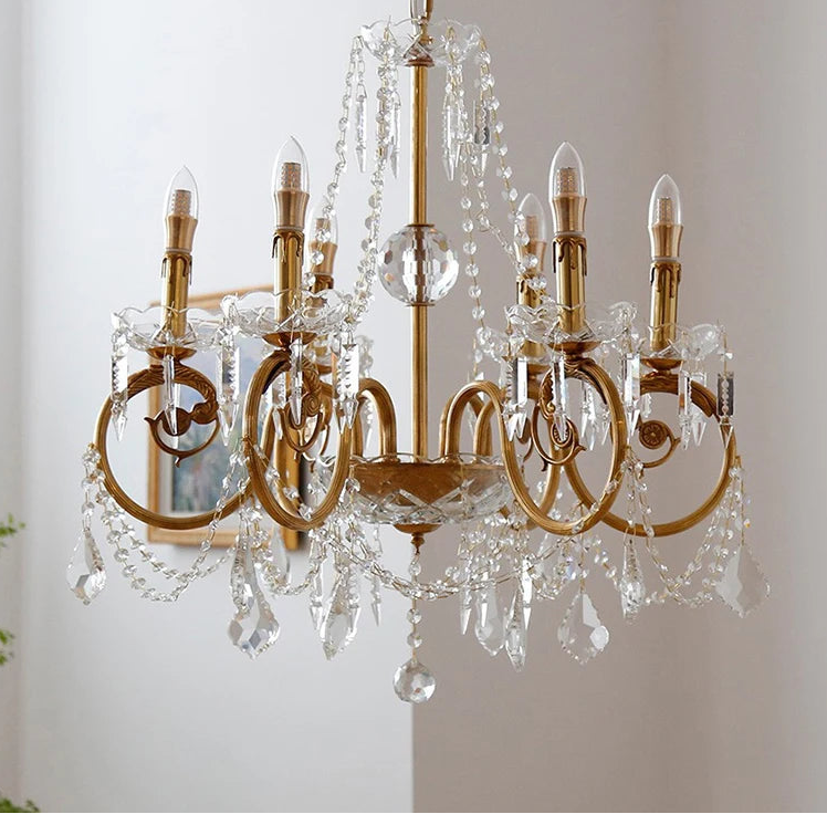 Gold chandelier with crystal accents on a neutral background