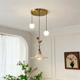 Gold floral rose bud ceramic pendant light with two white globe lights hanging from a brass circular canopy