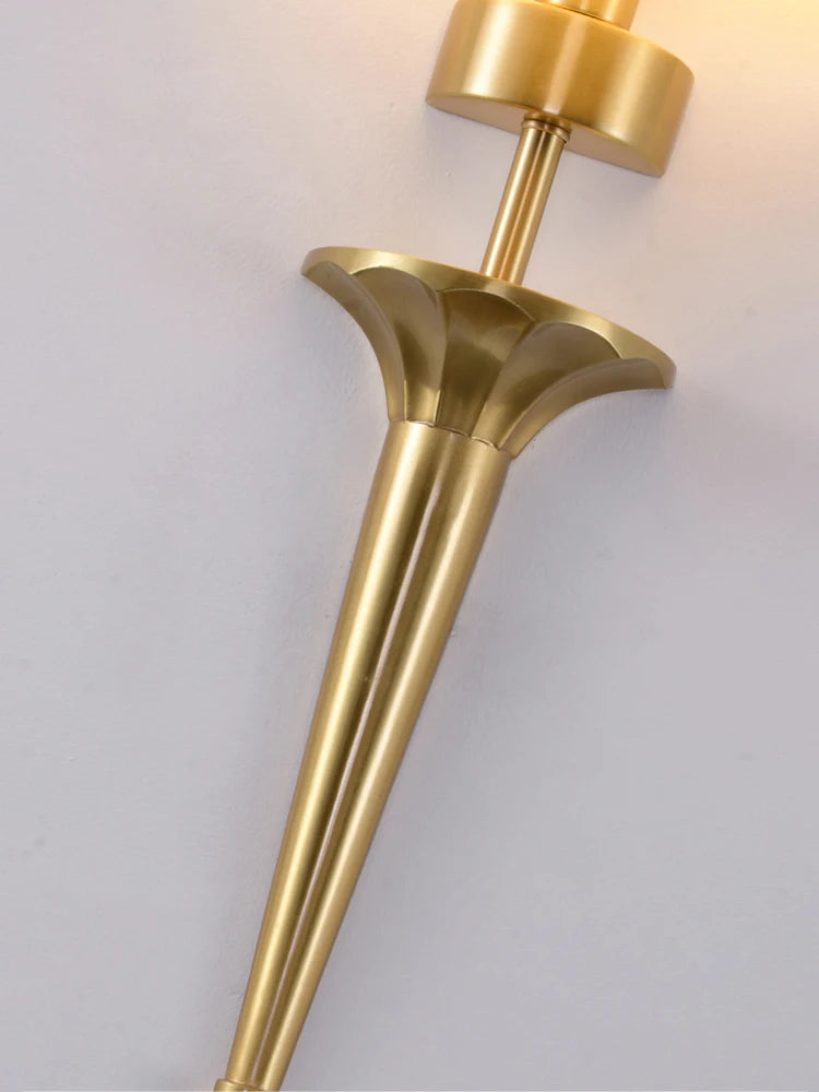 Gold wall sconce on a light gray background