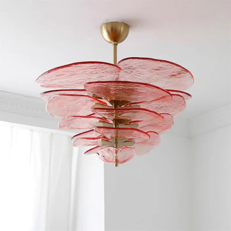 Pink glass chandelier with a layered, floral-inspired design and polished copper frame.