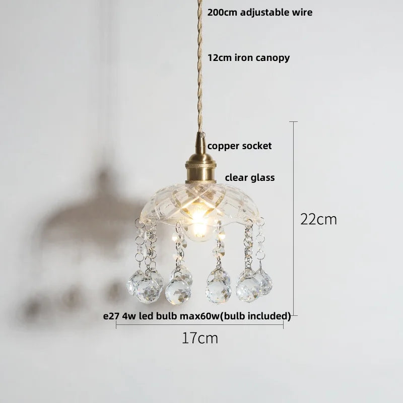 Pendant light with clear glass shade and measurements on a white background