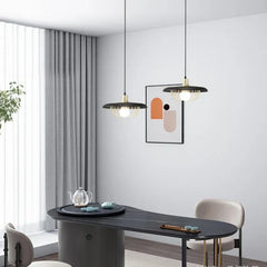 Wood-finish pendant light with gold cage hanging in a modern dining room setting.