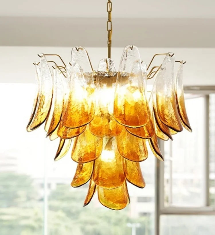Gold chandelier with glass shades in a room with large windows.