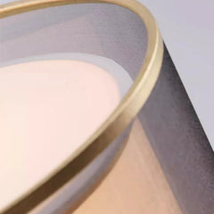 Close-up of a pink makeup compact with a gold lid on a gray background