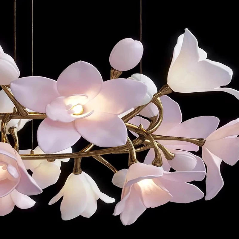Detailed shot of the luminous pink petals and buds of a flower-themed chandelier against a black background.