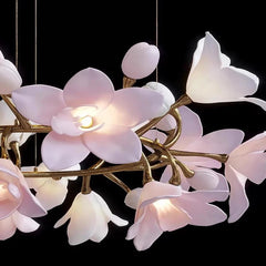 Detailed shot of the luminous pink petals and buds of a flower-themed chandelier against a black background.