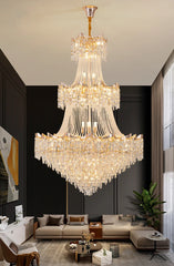 Luxurious chandelier hanging in a modern living room with dark walls and gray furniture.