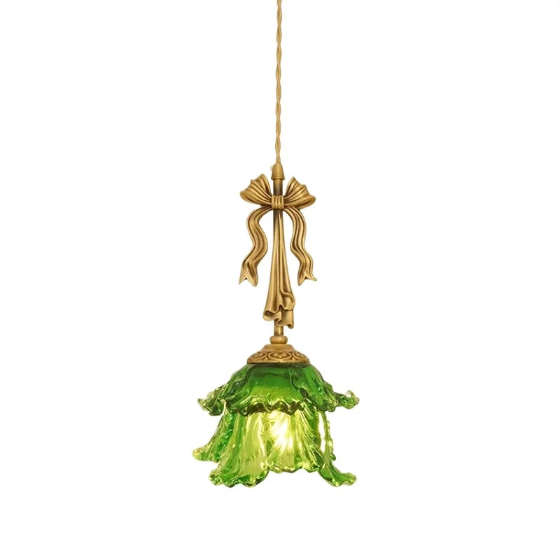 Decorative pendant light with green glass shade and gold fixture on a white background