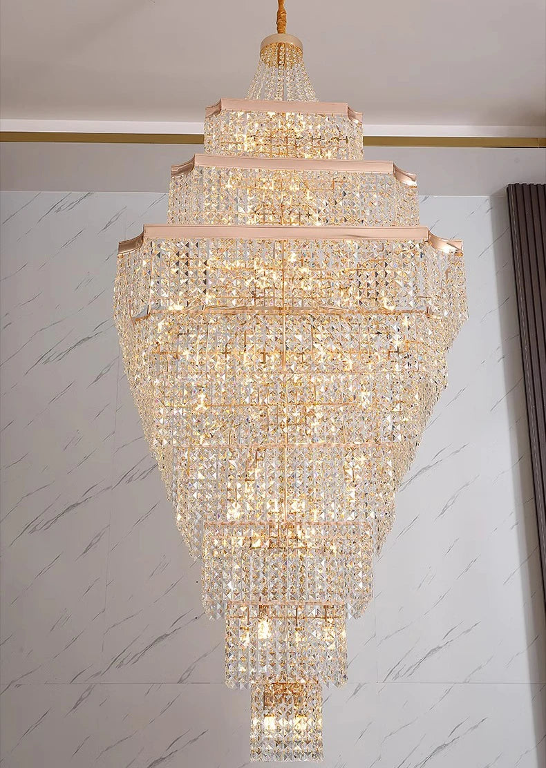 Luxurious crystal chandelier hanging against a marble wall.