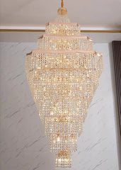 Luxurious crystal chandelier hanging against a marble wall.