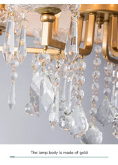 Close-up view of the cascading clear crystals and gold frame of the chandelier.