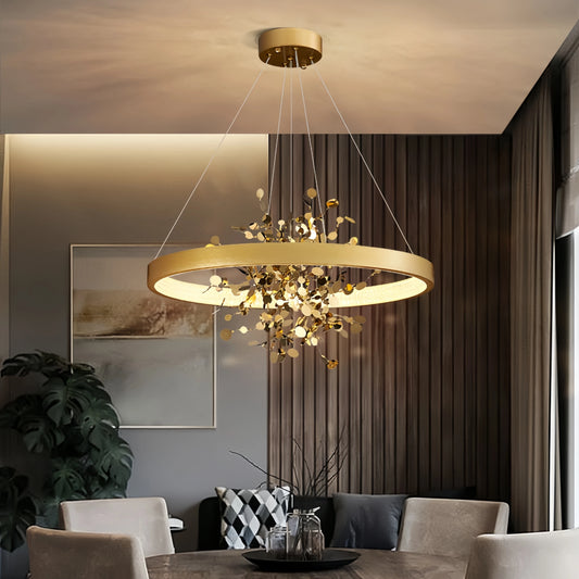 Gold ring pendant light with cascading floral accents hanging above a dining table.