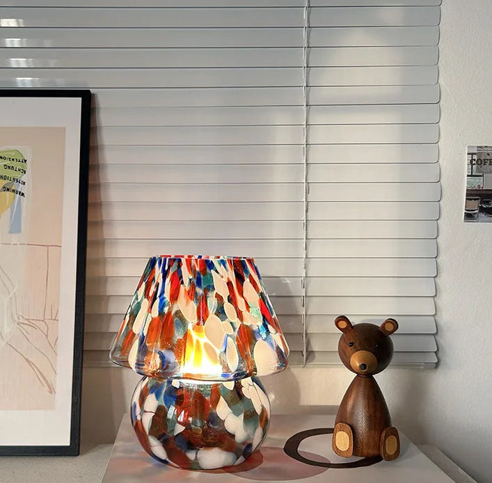 Colorful lamp with a wooden bear figure on a shelf in a room setting.