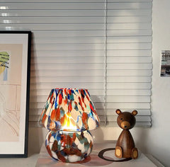 Colorful lamp with a wooden bear figure on a shelf in a room setting.