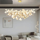Gold ginkgo leaf cluster pendant light hanging above a sofa in a modern living room