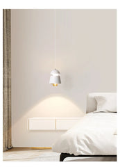 Modern bedroom with a bed, nightstand, and pendant light.