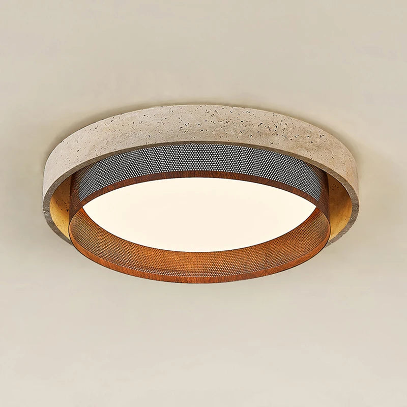 Close-up of a circular flush mount ceiling light with a textured, stone-like outer ring and a perforated metal band, emitting a warm light.