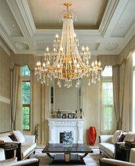Luxurious living room with a grand chandelier, fireplace, and elegant decor.