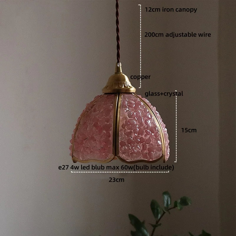 Pendant light with pink glass shade and measurements on a neutral background