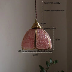 Pendant light with pink glass shade and measurements on a neutral background