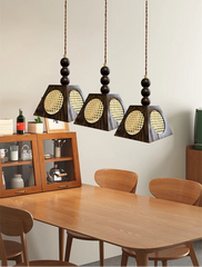 Three pendant lights hanging above a wooden dining table with chairs.
