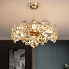 A gold and crystal tiered semi-flush ceiling light with fan blades retracted, viewed from a slightly lower angle.