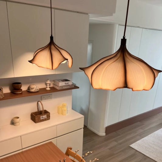 Two artistic petal-shaped pendant lights hanging in a modern kitchen setting.