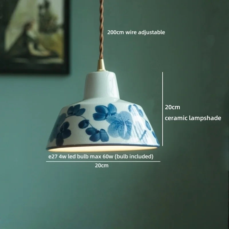 Ceramic lampshade with blue floral design on a green wall background
