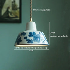 Ceramic lampshade with blue floral design on a green wall background