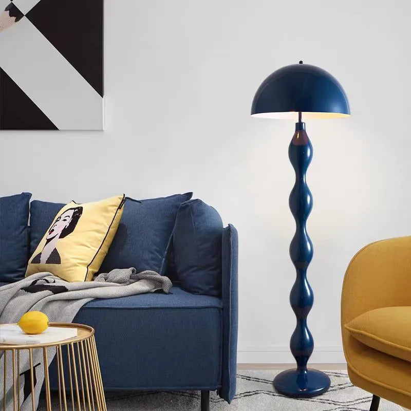 Blue mushroom floor lamp with a segmented base next to a blue sofa.